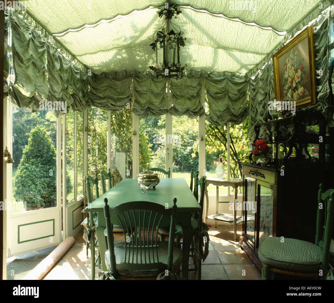Festoon blinds in conservatory extension with green dining table and