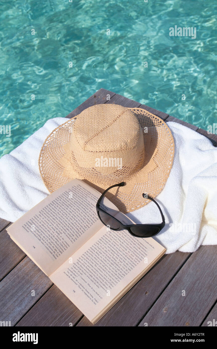 Straw hat book and sunglasses on towel North Male Atoll Maldives Indian ...