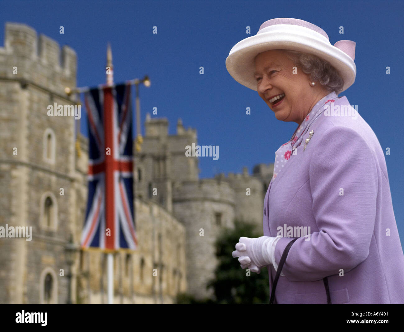 QUEEN ELIZABETH II Windsor Castle exterior happy smiling HRH Queen Elizabeth II in grounds of Windsor Castle Union Jack flag behind UK (also 2HG5K5F) Stock Photo