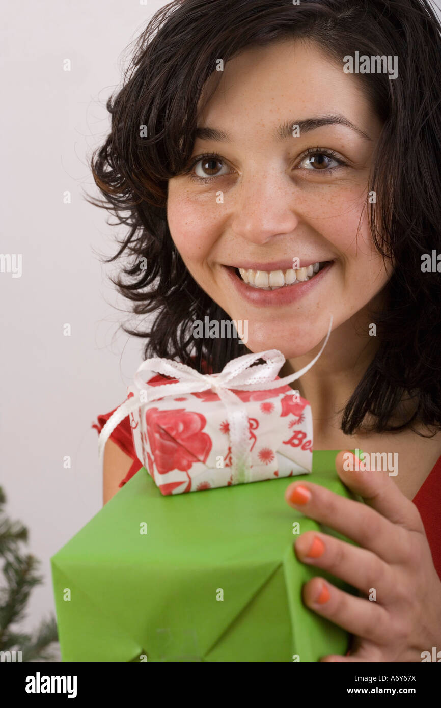 Woman holding gift and smiling Stock Photo - Alamy