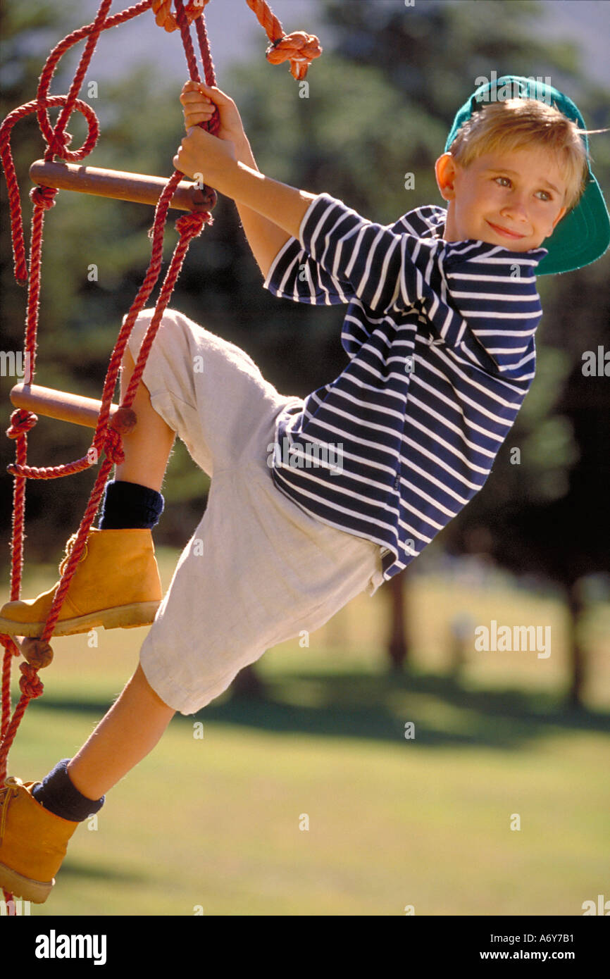 portrait of a boy climbing on a rope ladder in the park Stock Photo