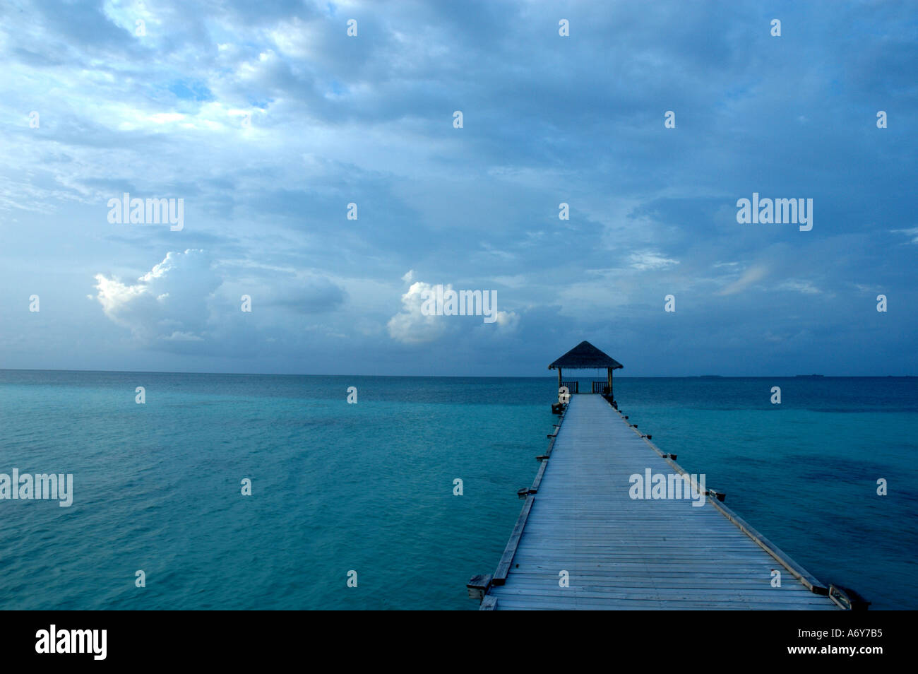 View of wooden jetty at sunset in shallow lagoon waters Maldives Stock Photo