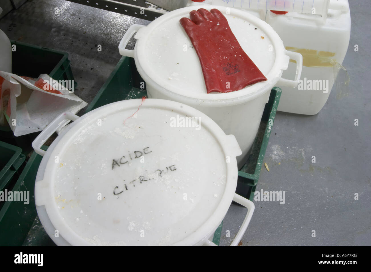 Plastic bucket with Acide Citrique, Citric Acid, C6H8O7, frequently used in wine production. Citrus. With a rubber glove. Mas La Chevaliere. near Beziers. Languedoc. France. Europe. Stock Photo