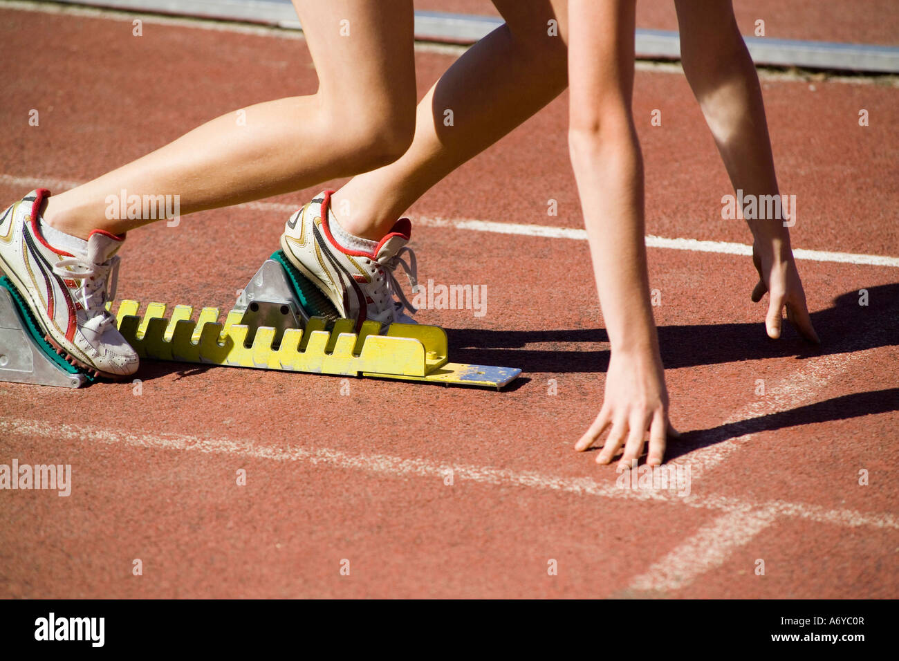 Female athlete running from starting blocks Stock Photo Alamy