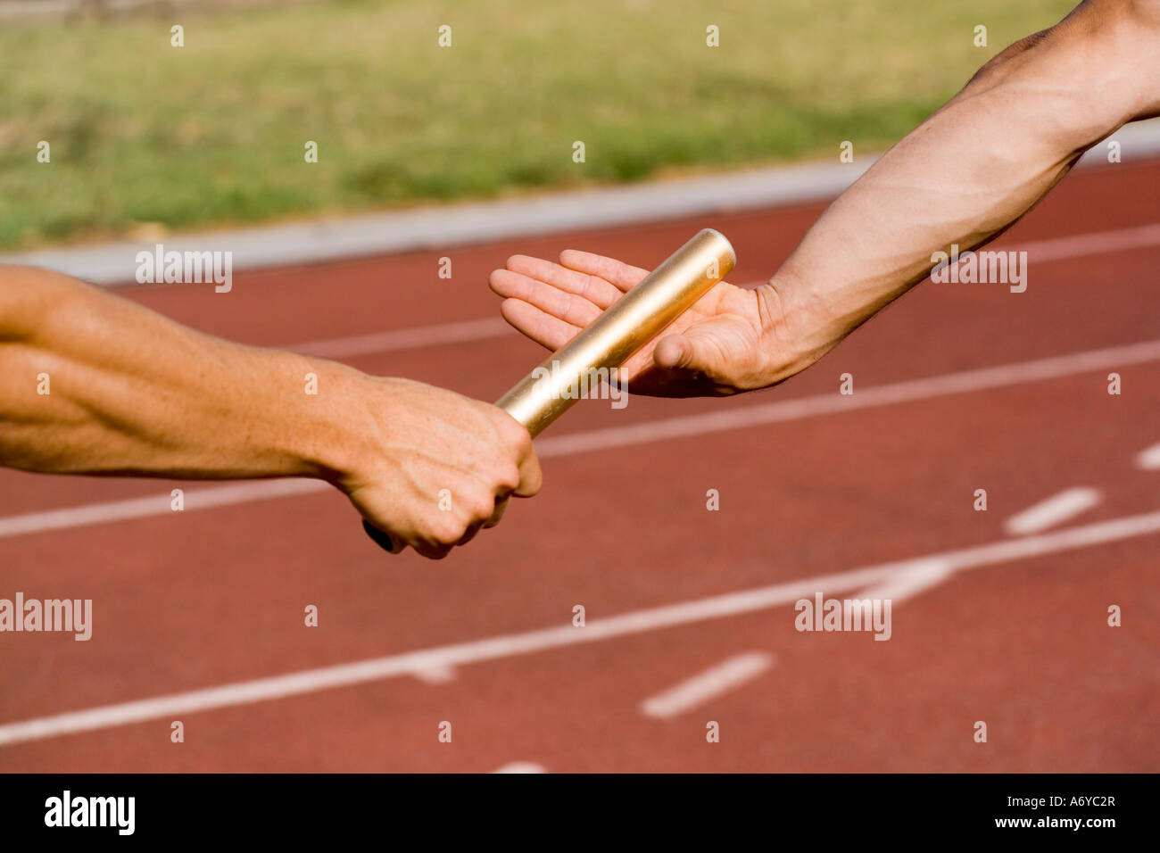 Two athletes exchanging a baton during a relay race Stock Photo Alamy