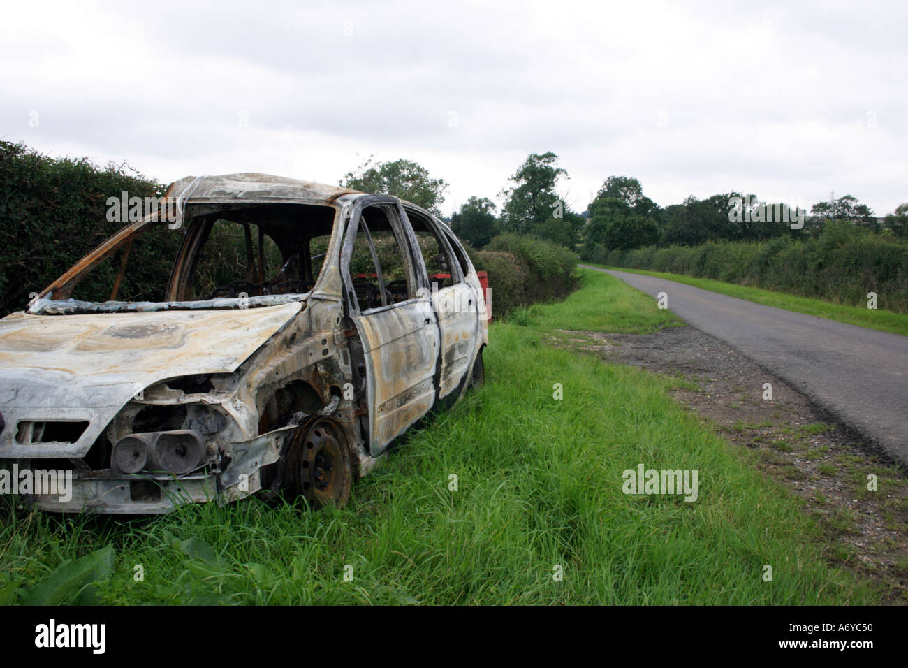 Burnt out car in countryside Stock Photo
