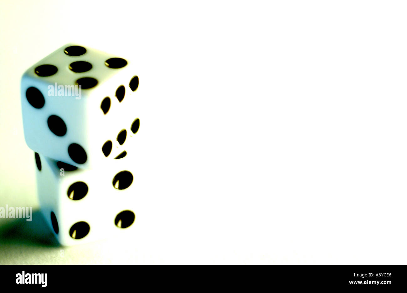 Vertical Color Image Of White Dce With Black Dots On A Plain White