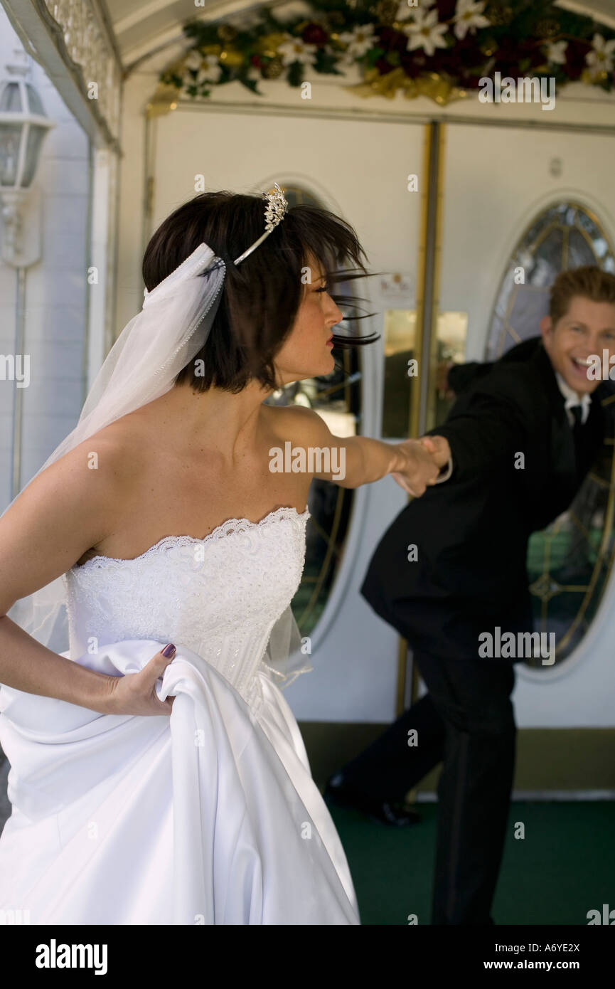 Groom dragging bride into a wedding chapel Stock Photo