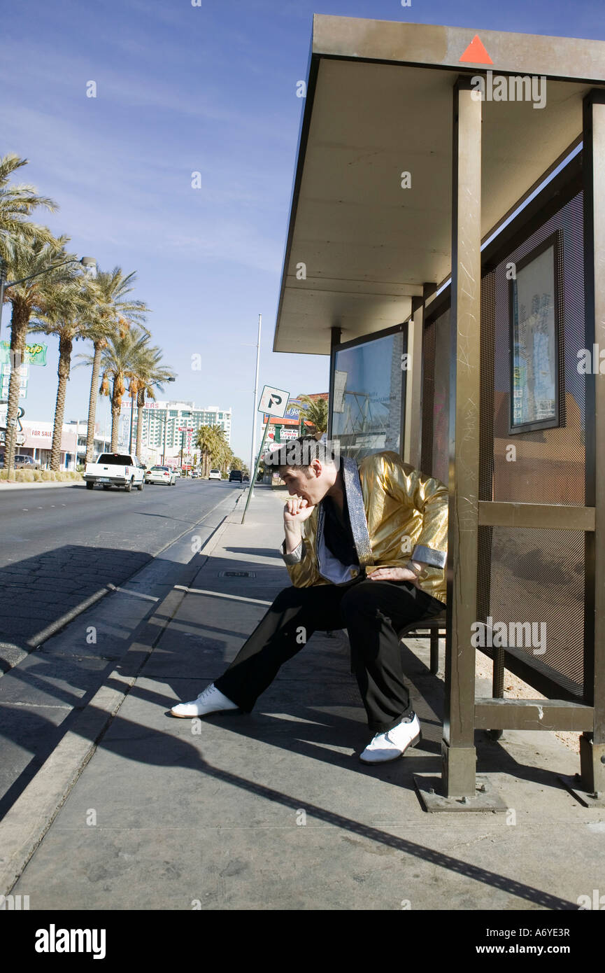 Elvis impersonator posing at a bus stop Stock Photo