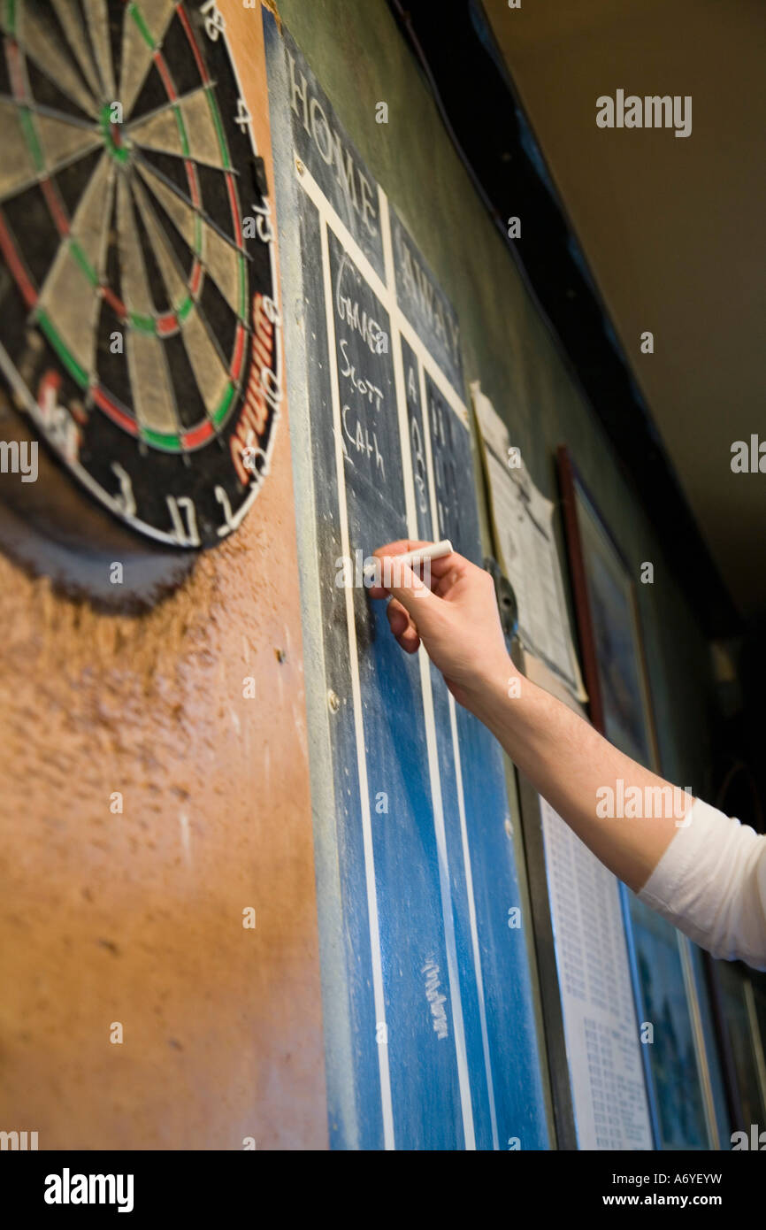 Person keeping score on a blackboard during a game of darts Stock Photo