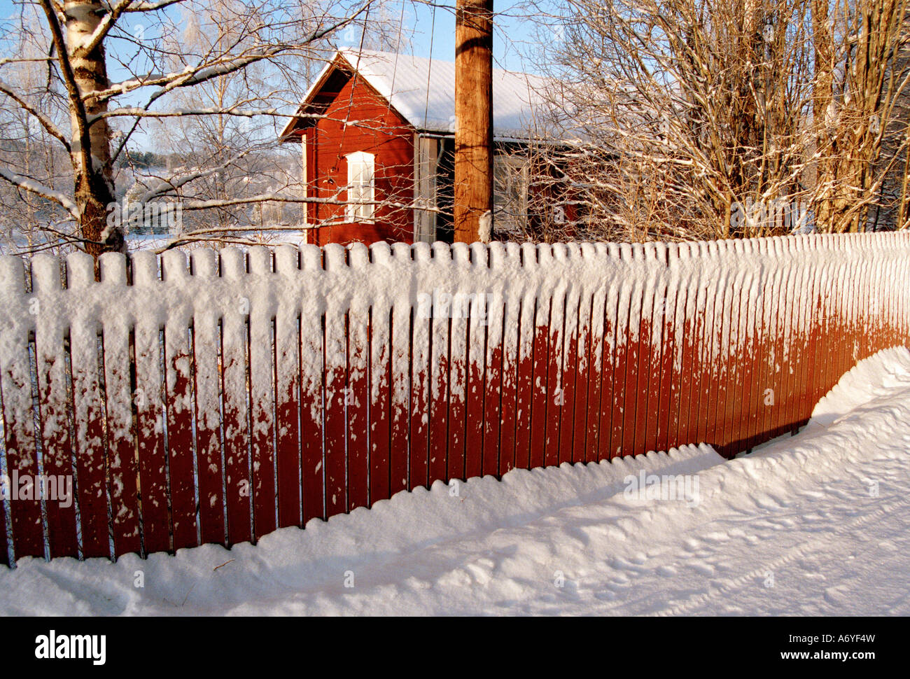 Snow capped house behind a picket fence Sweden Stock Photo