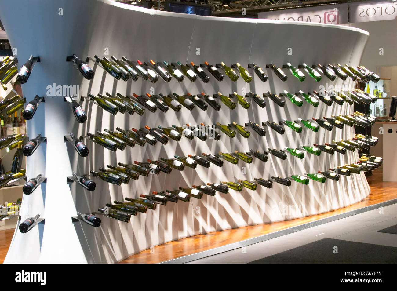One of the exhibition booths displaying rows of wine bottles in curved