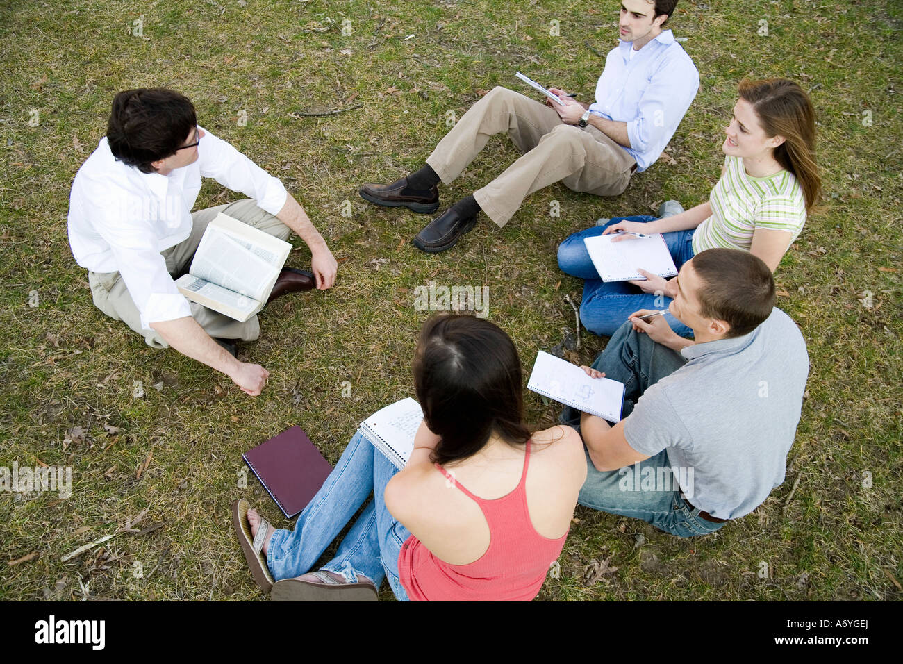 University students sitting on grass with lecturer Stock Photo - Alamy