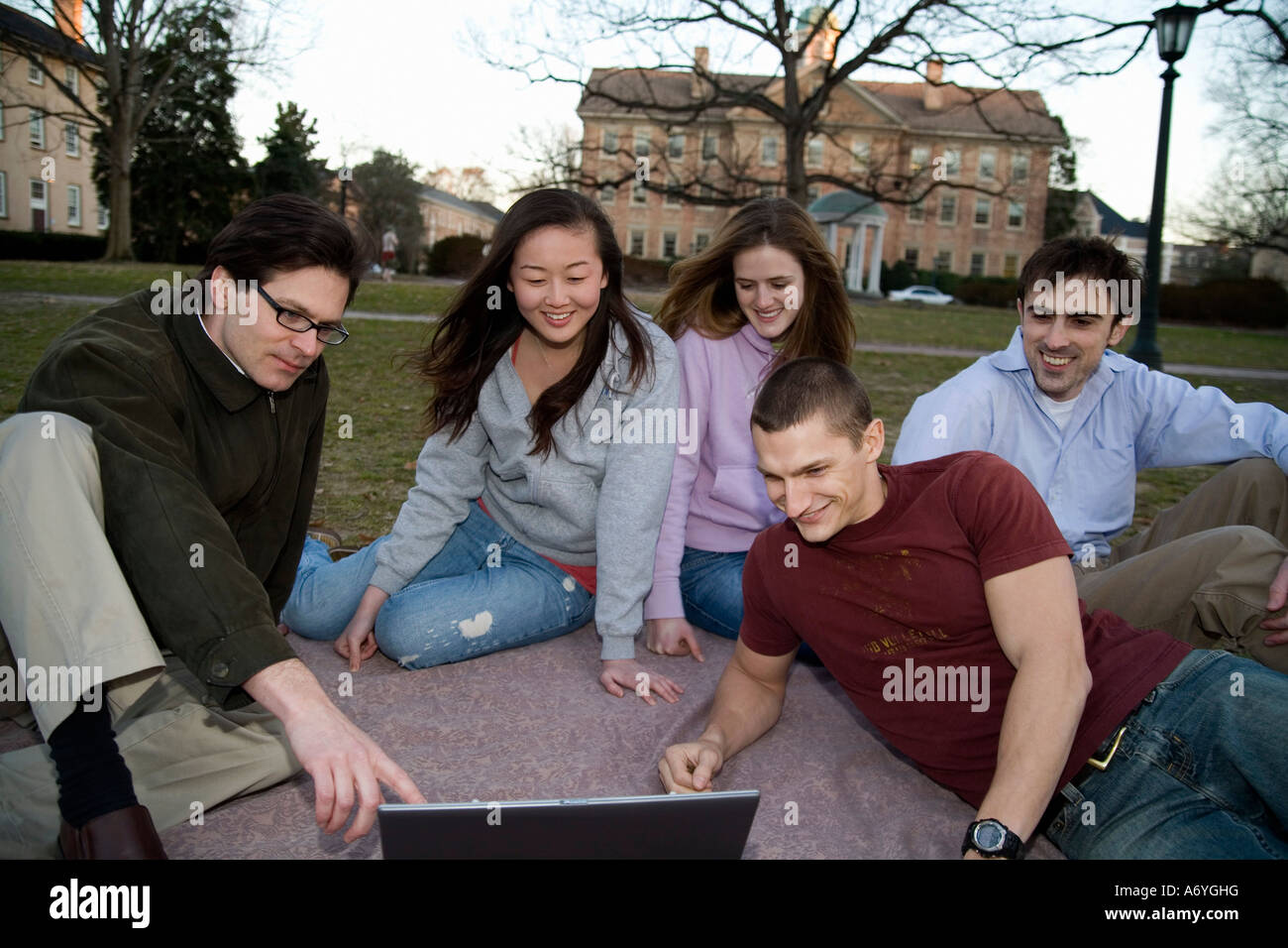 University students sitting on grass with lecturer Stock Photo - Alamy