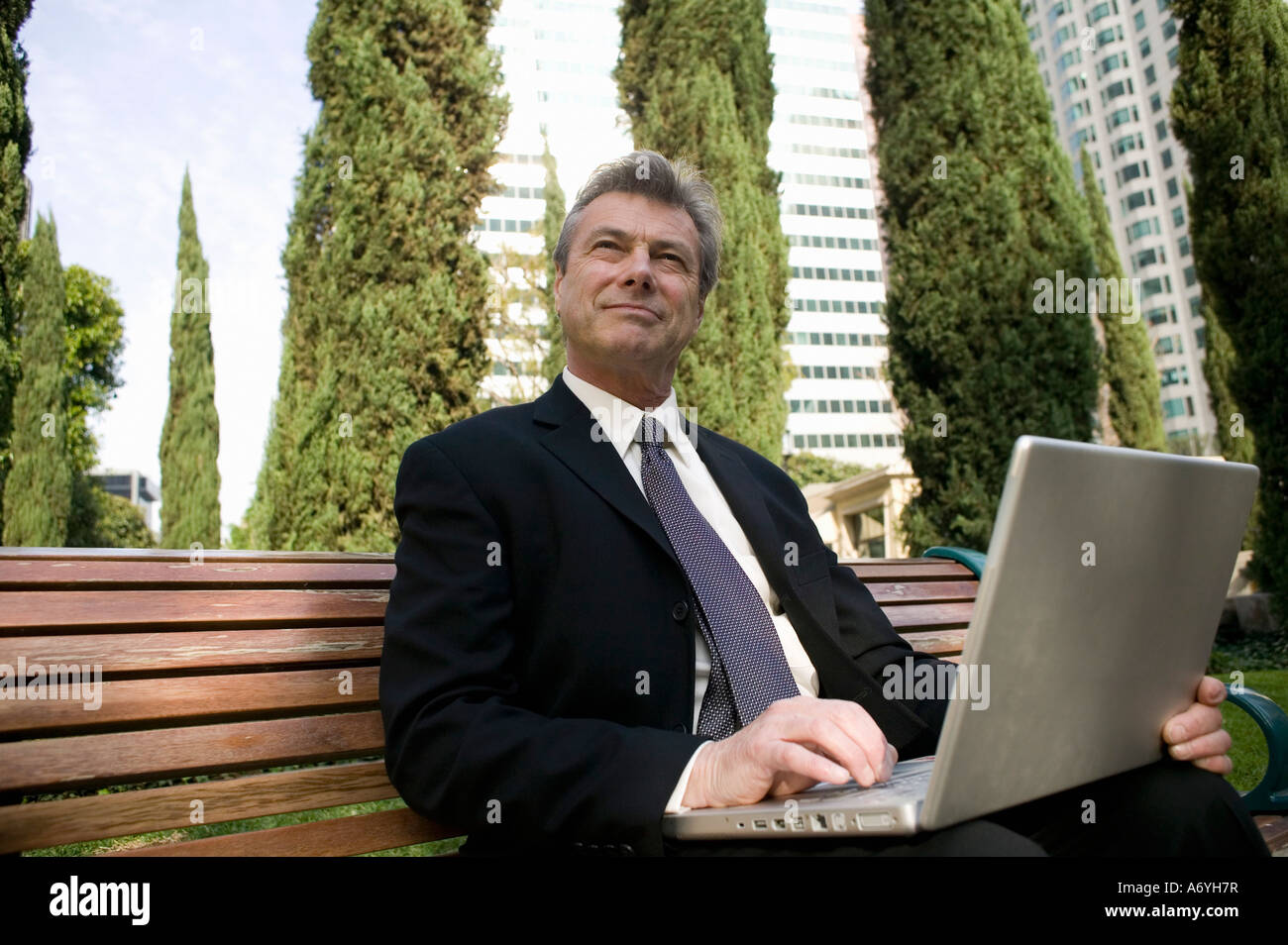 Businessman sitting on a bench in park hi-res stock photography and ...