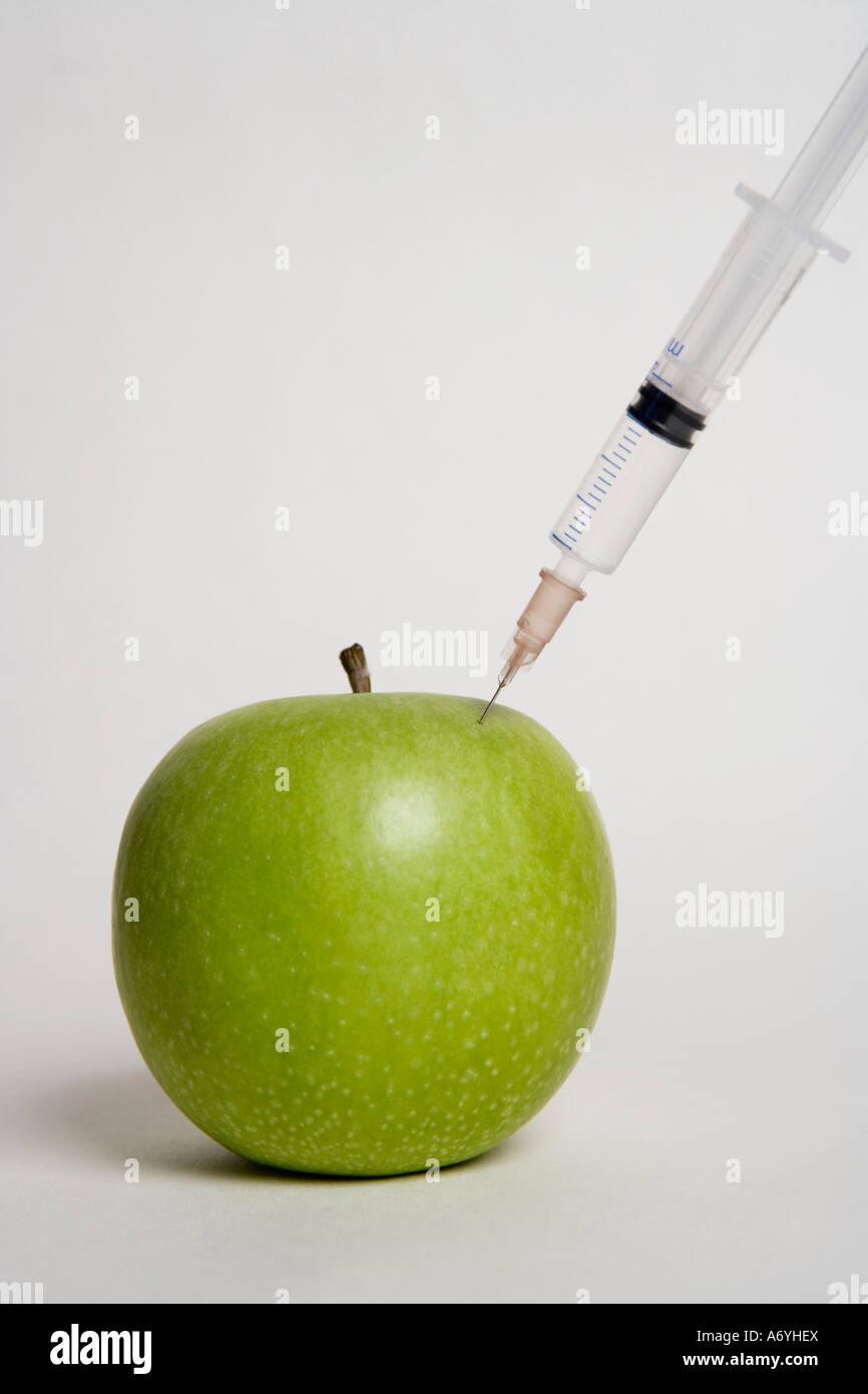A syringe injecting an apple Stock Photo - Alamy