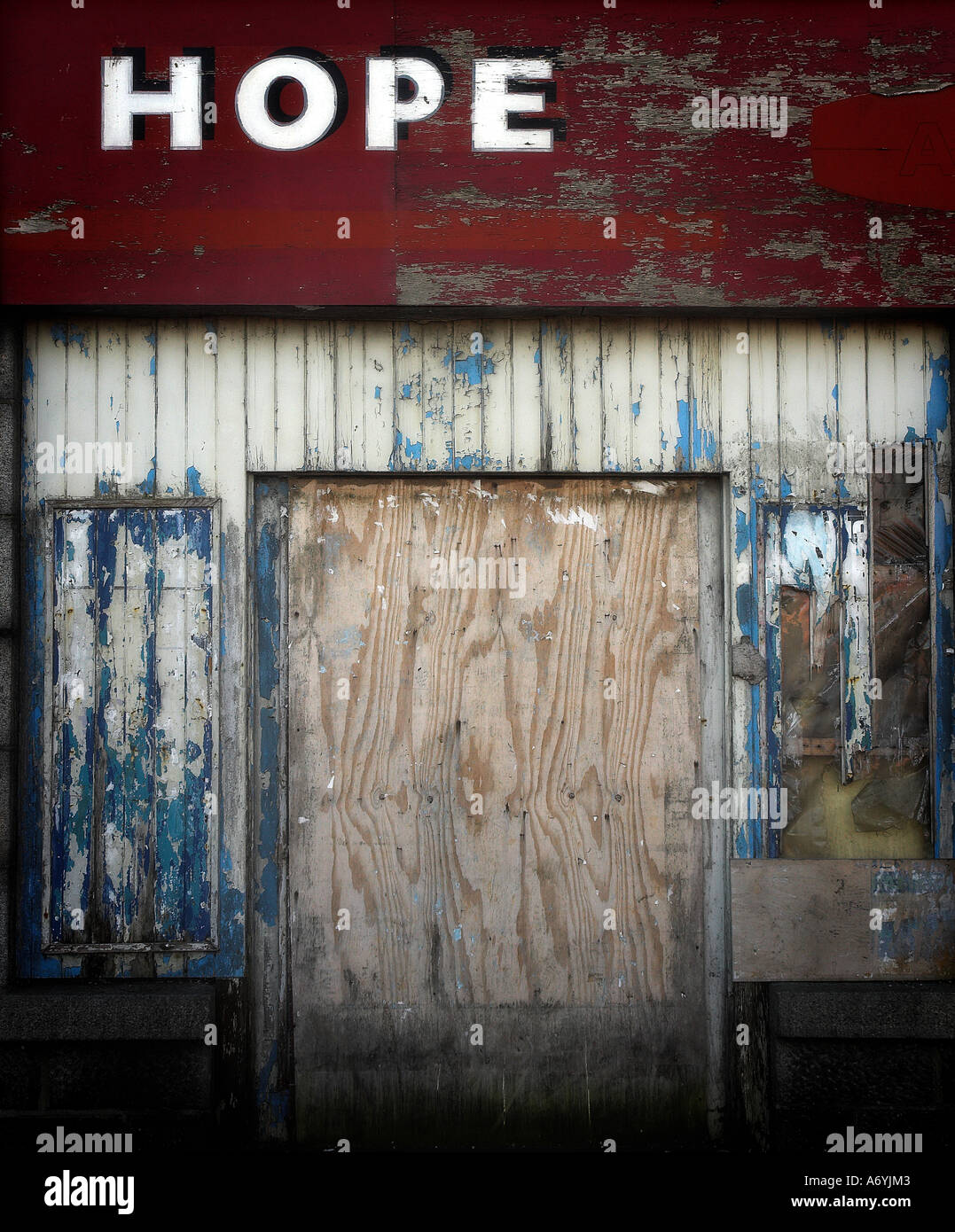 A portrait format image of a derelict shop front with the words 'Hope' highlighted above doorway. Stock Photo