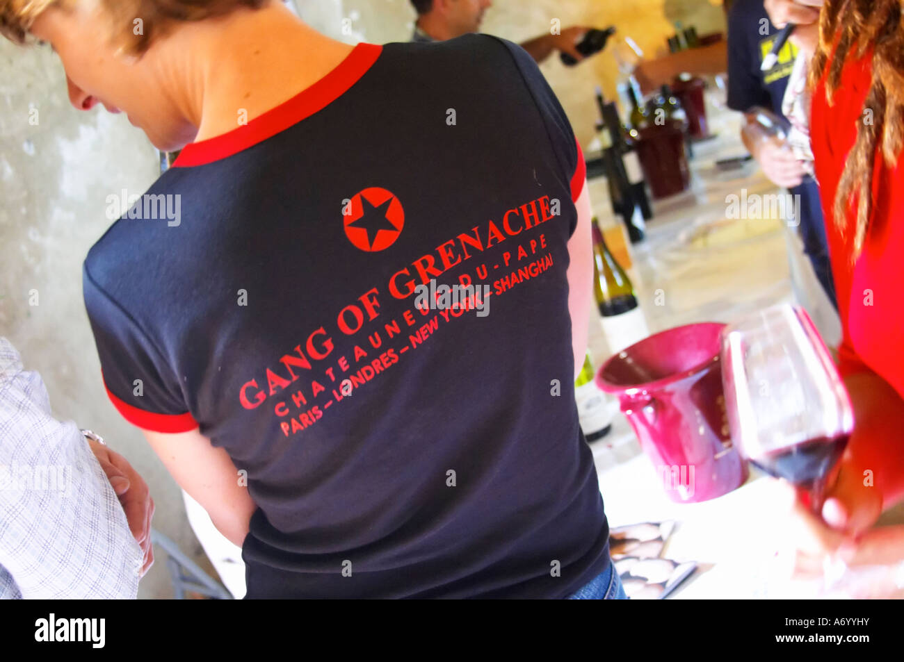 A wine taster with a black t-shirt tshirt saying 'The Gang of Grenache' advertising a group of Chateauneuf-du-Pape growers. Rhone. Tasting wine. Ice bucket. France Europe. Stock Photo