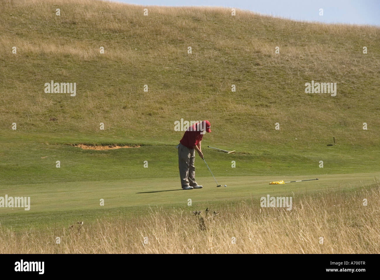 Golfer putting on public golf course Cleeve Hill The Cotswolds