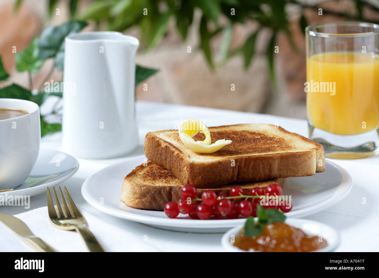 Breakfast toasts with butter jam coffee with milk fruit and juice Stock