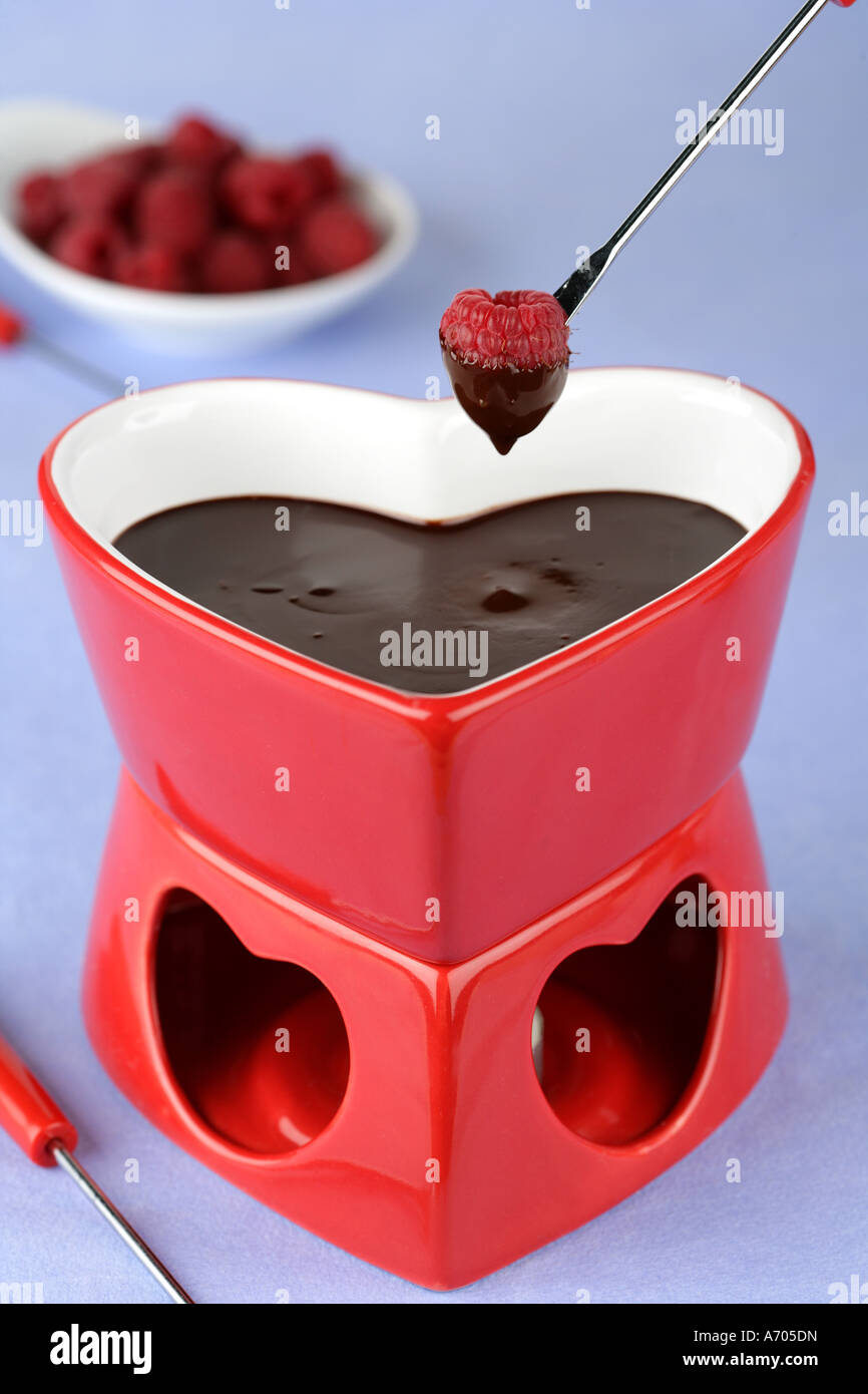 Heart shaped chocolate fondue dipping a raspberry  Stock Photo