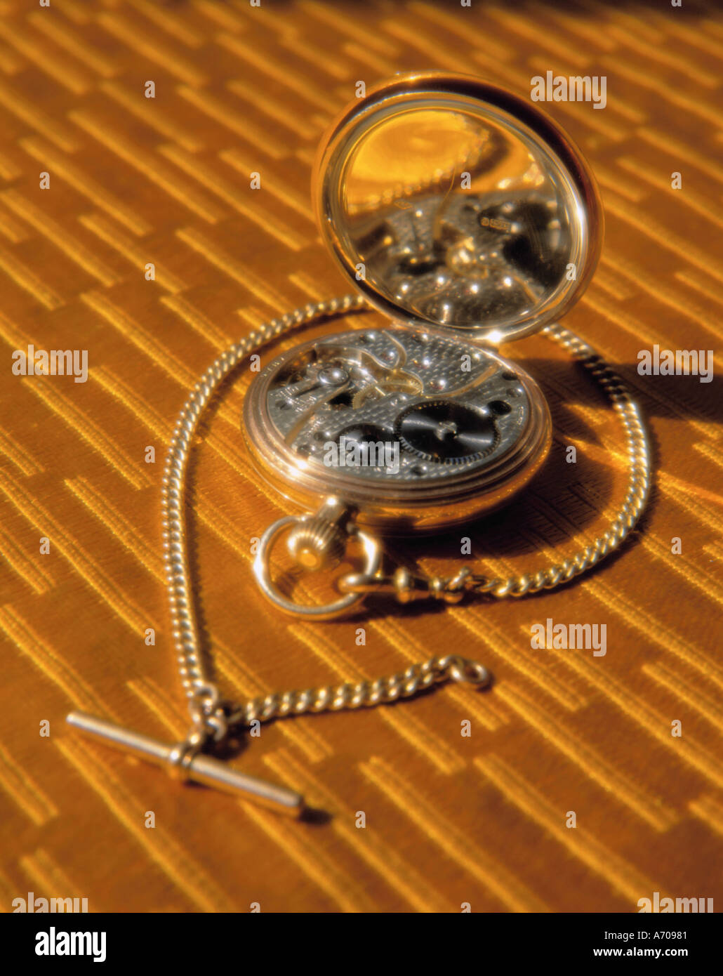 Gold pocket watch with back open to show clockwork mechanism Stock