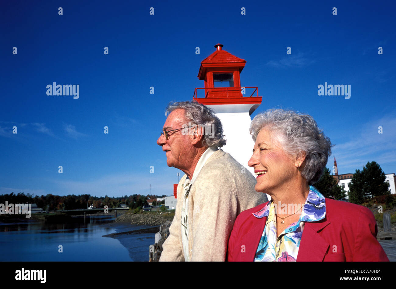 senior couple looking at Calais Maine with lighthouse in background and St Croix River Stock Photo