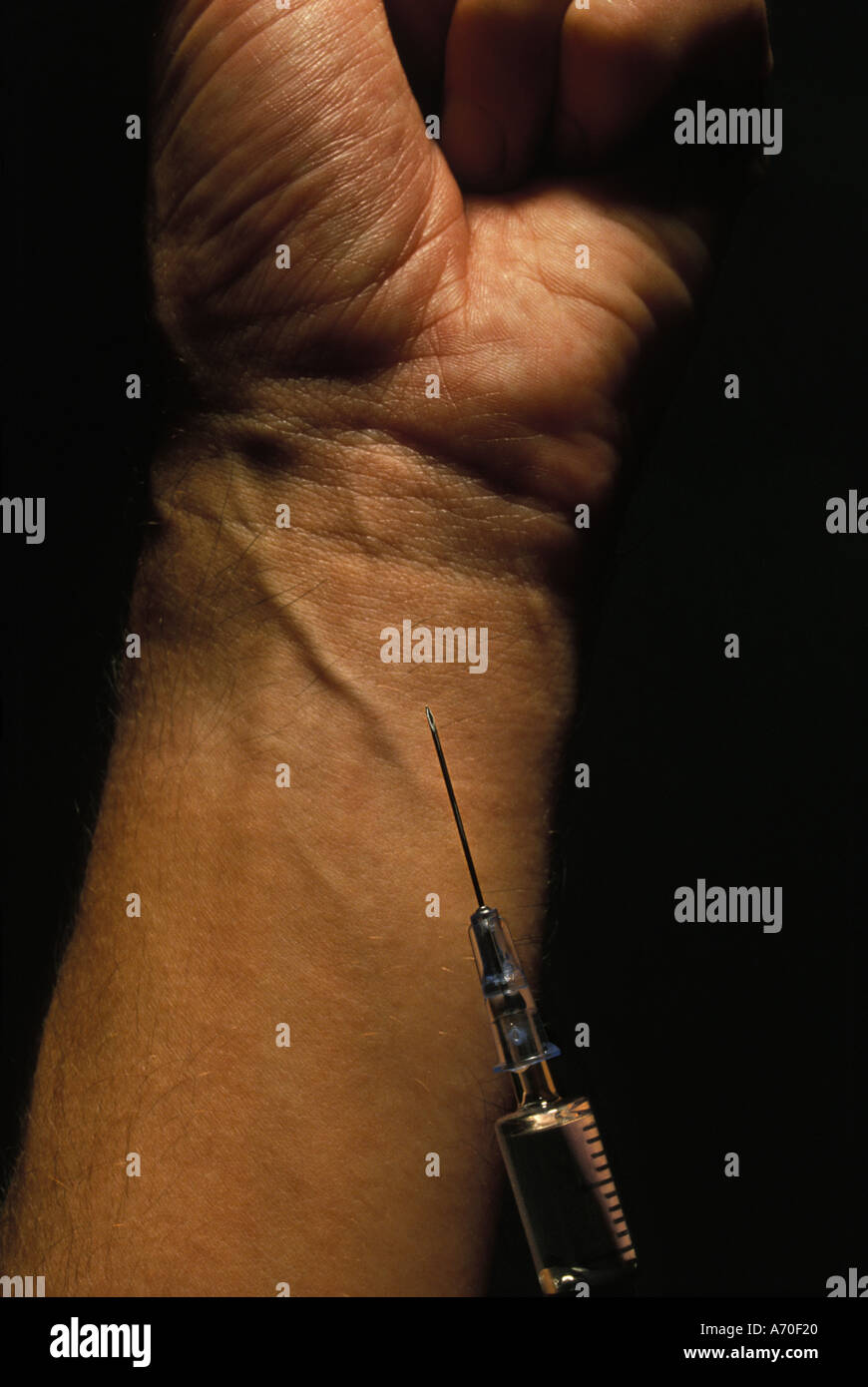 injecting drugs into arm Stock Photo