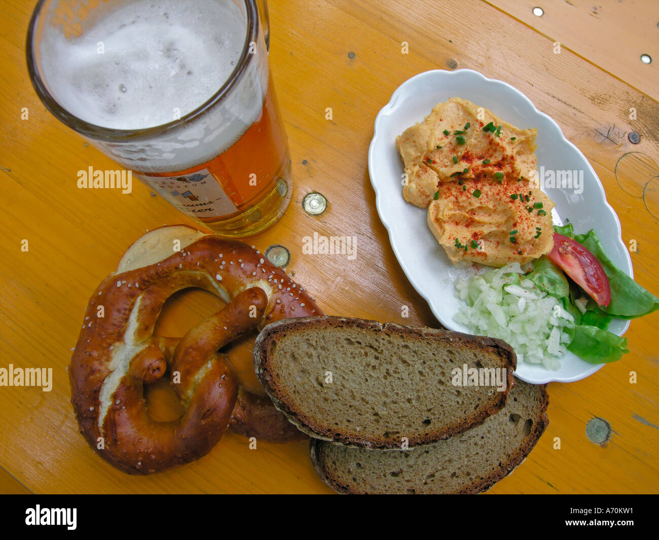 bavarian Brotzeit snack in beer garden with beer pretzel bread and Obazter typical bavarian cheese spread on wooden table Stock Photo