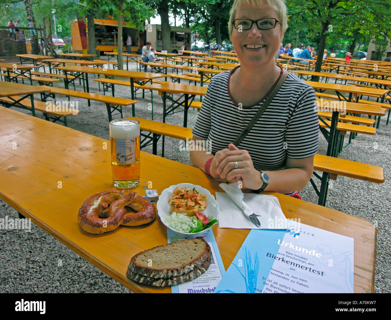 woman takes snack Brotzeit in empty beer garden Stock Photo