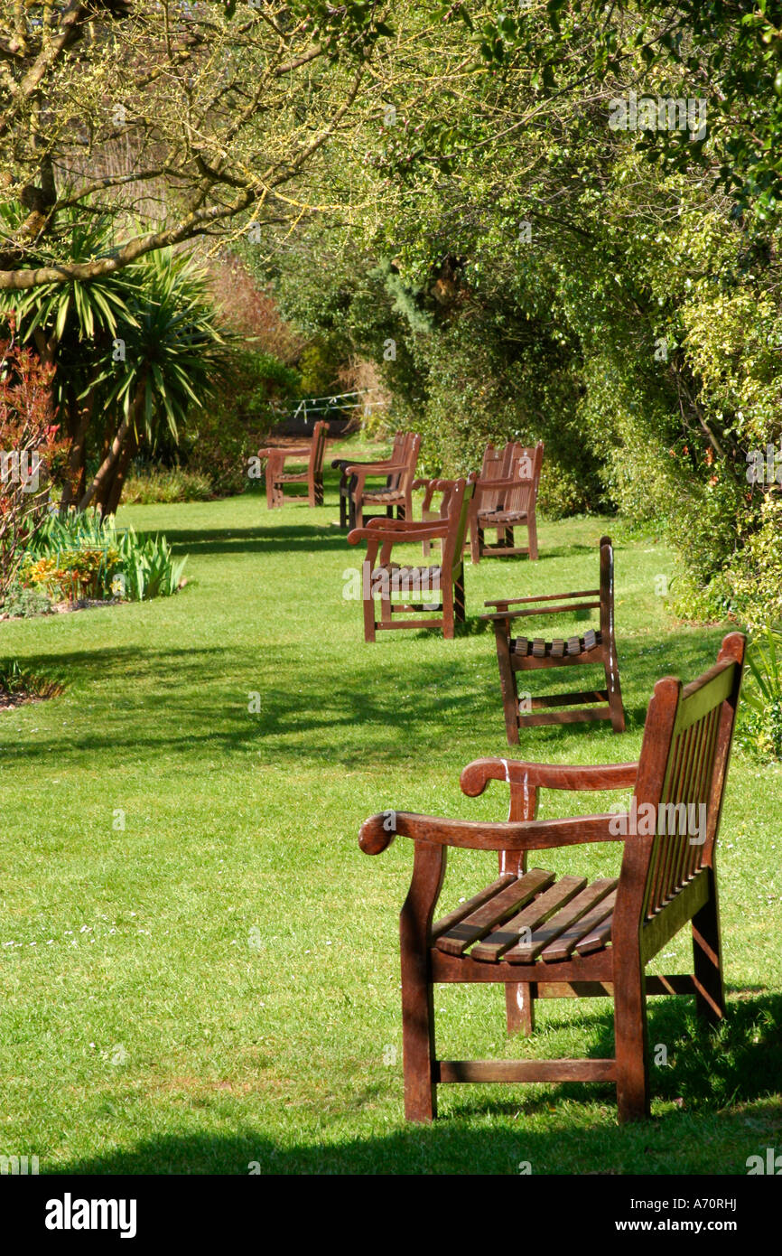 Row of empty wooden garden seats in Highdown Gardens, West Sussex, England, UK Stock Photo