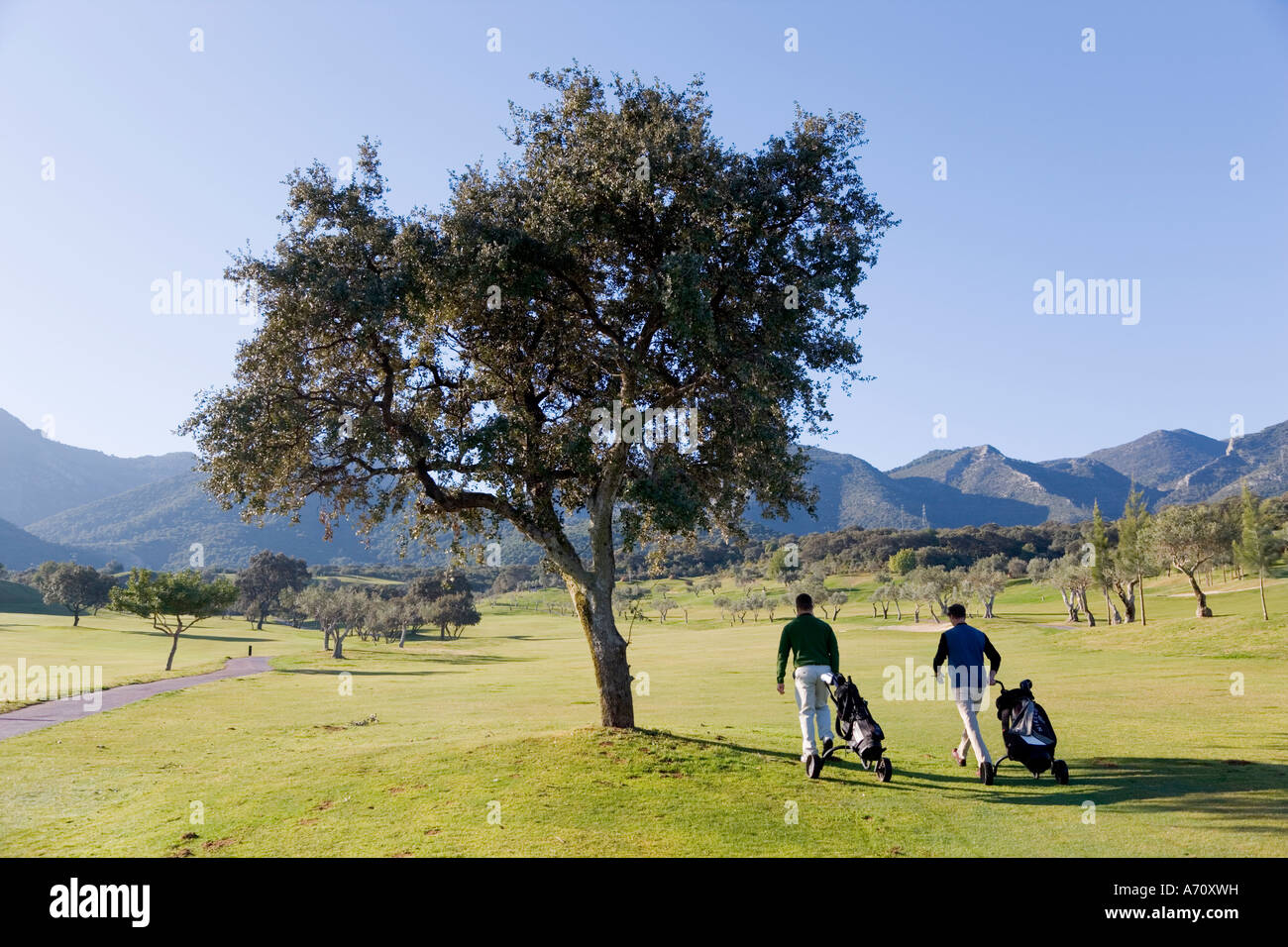 Alhaurin de la Torre,  Malaga Province,  inland Costa del Sol, southern Spain.  Lauro Golf course. Two men walking on fairway. Stock Photo