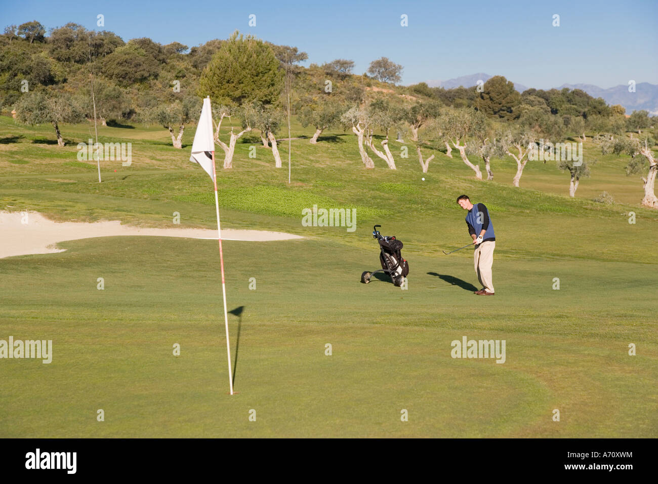 Alhaurin de la Torre,  Malaga Province,  inland Costa del Sol, southern Spain.  Lauro Golf course. Man chipping onto green. Stock Photo