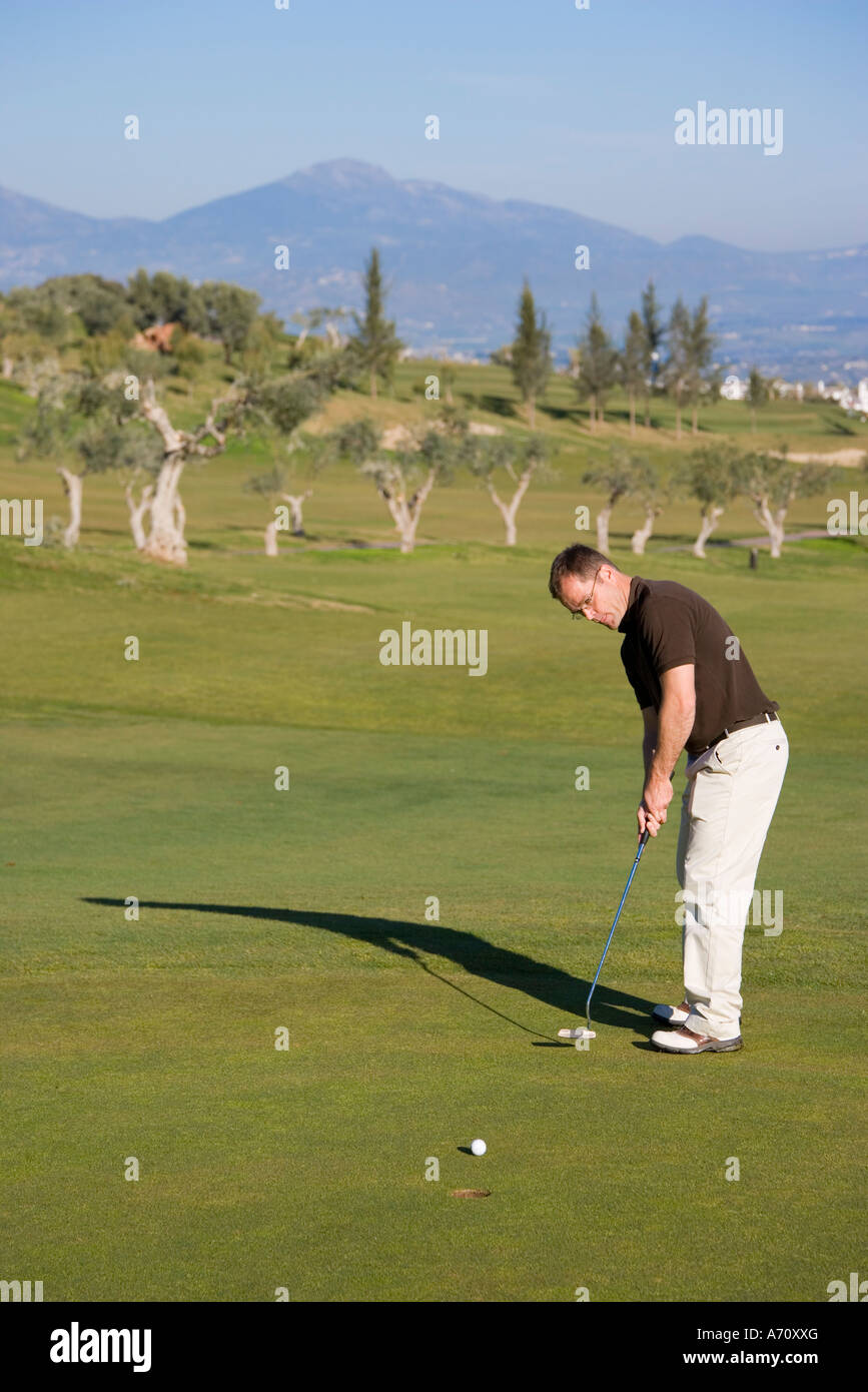 Alhaurin de la Torre,  Malaga Province,  inland Costa del Sol, southern Spain.  Lauro Golf course. Man putting on green. Stock Photo