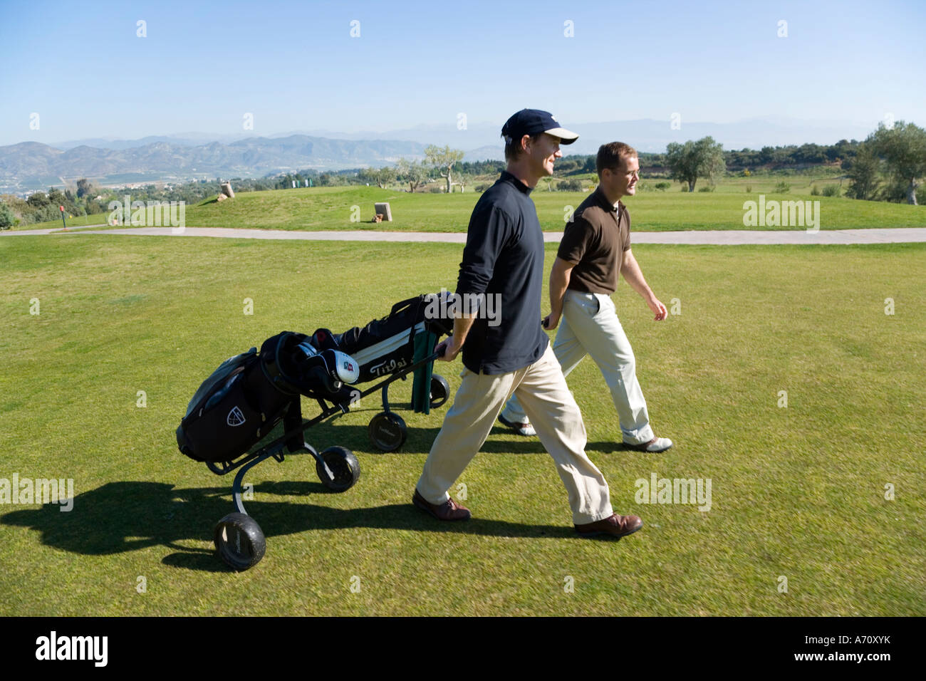 Alhaurin de la Torre,  Malaga Province, inland Costa del Sol, southern Spain.  Lauro Golf course. Two golfers walking of fairway Stock Photo