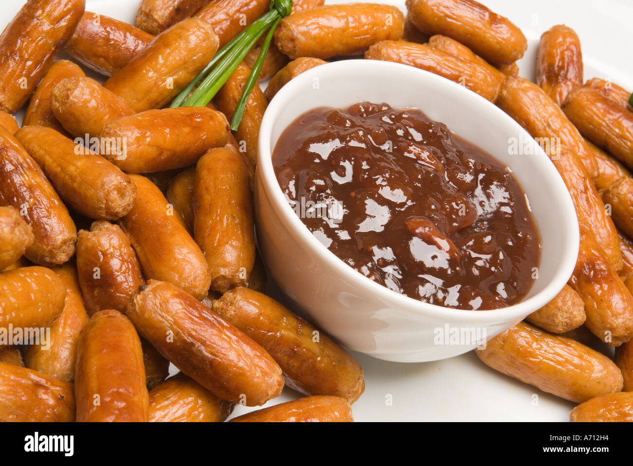 food plate of fried cocktail sausages with savoury dip Stock Photo