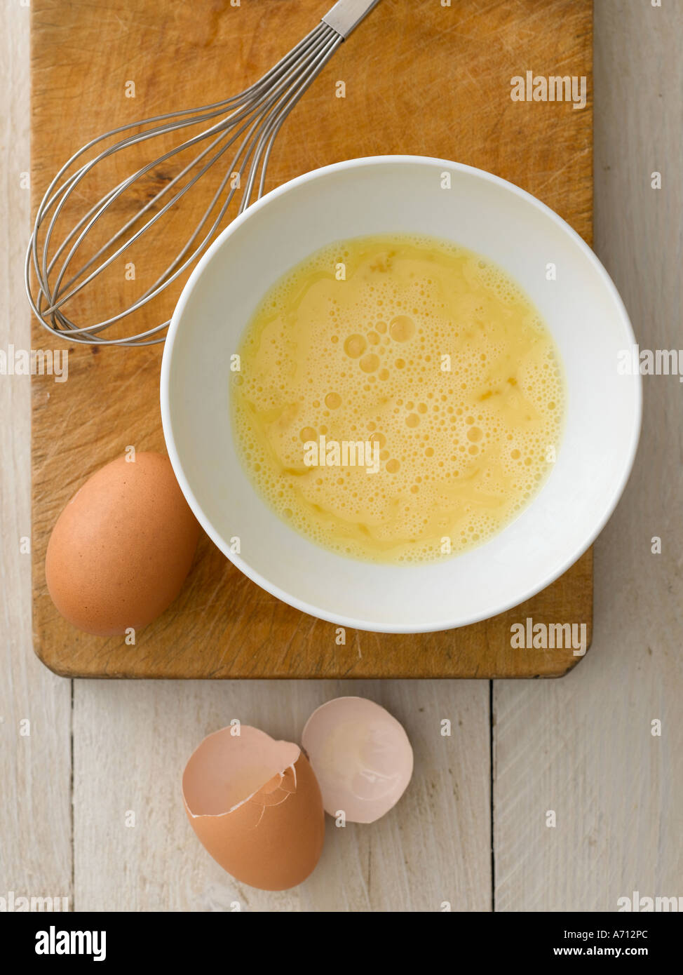 Raw eggs beaten in ceramic bowl with whisk and shells - high end Hasselblad 61mb digital image Stock Photo