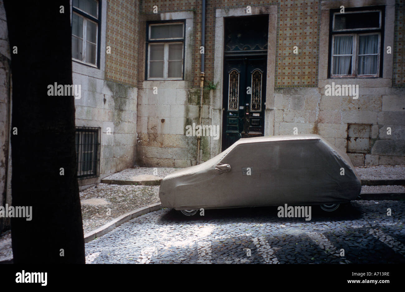 Car under cover in a cobbled street of old neighborhood in Lisbon