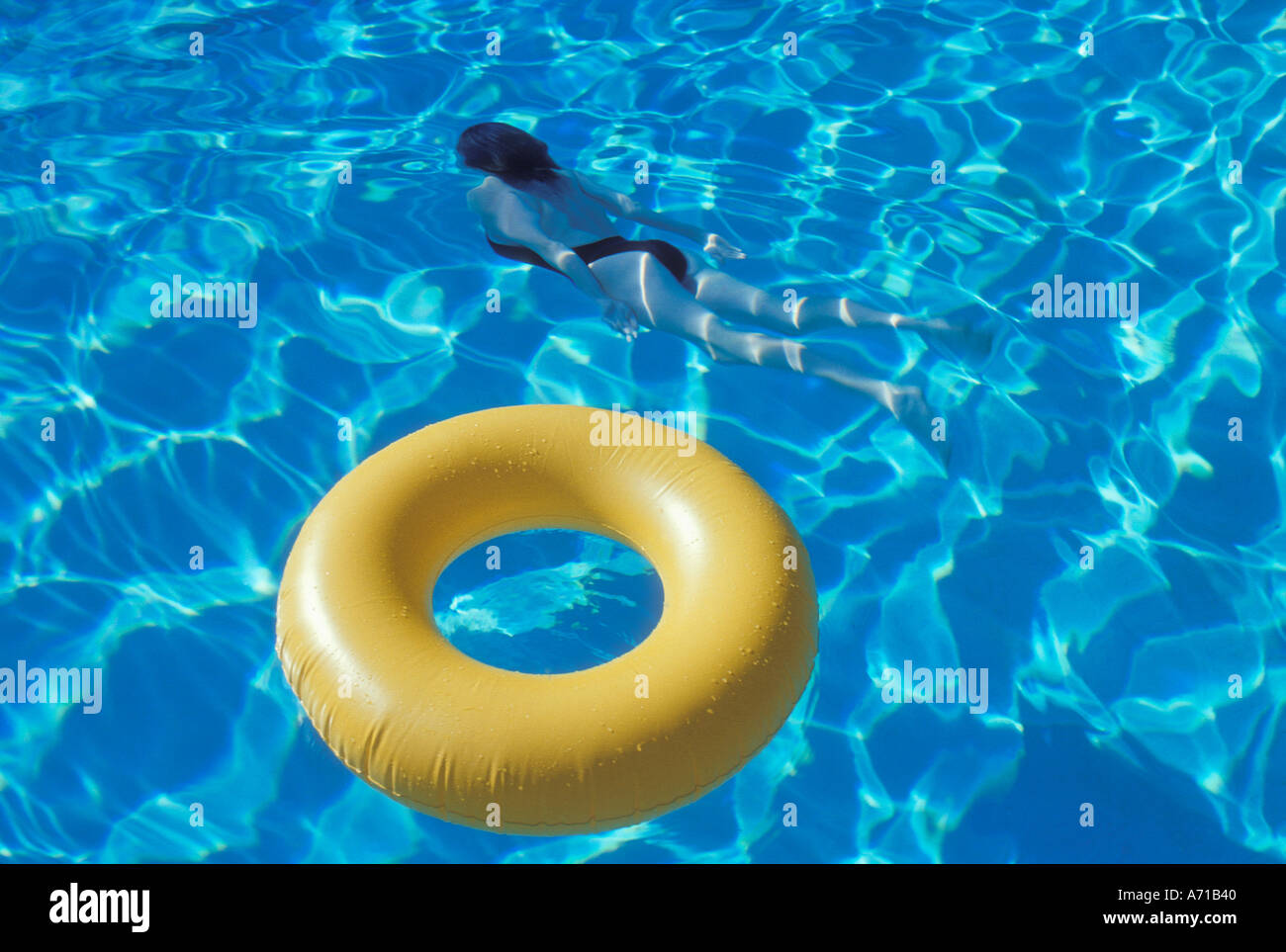 Yellow inner tube in swimming pool with woman underwater in Stock Photo ...