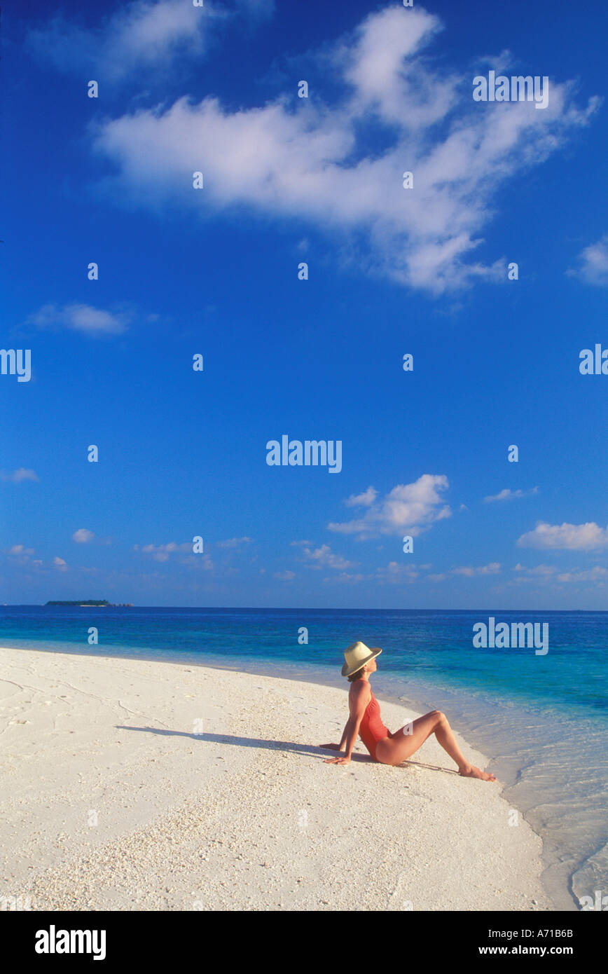 Woman sitting on beach in the Maldives Indian Ocean model released image Stock Photo
