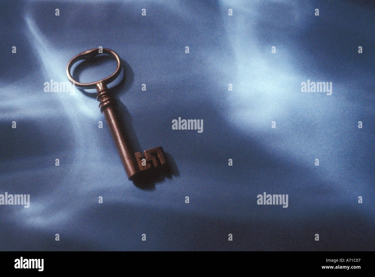 Antique key on table with dappled lighting Stock Photo