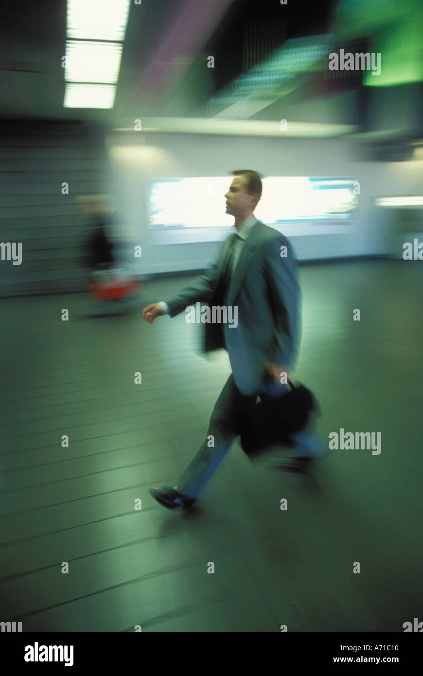 Businessman in motion through airport model released image Stock Photo