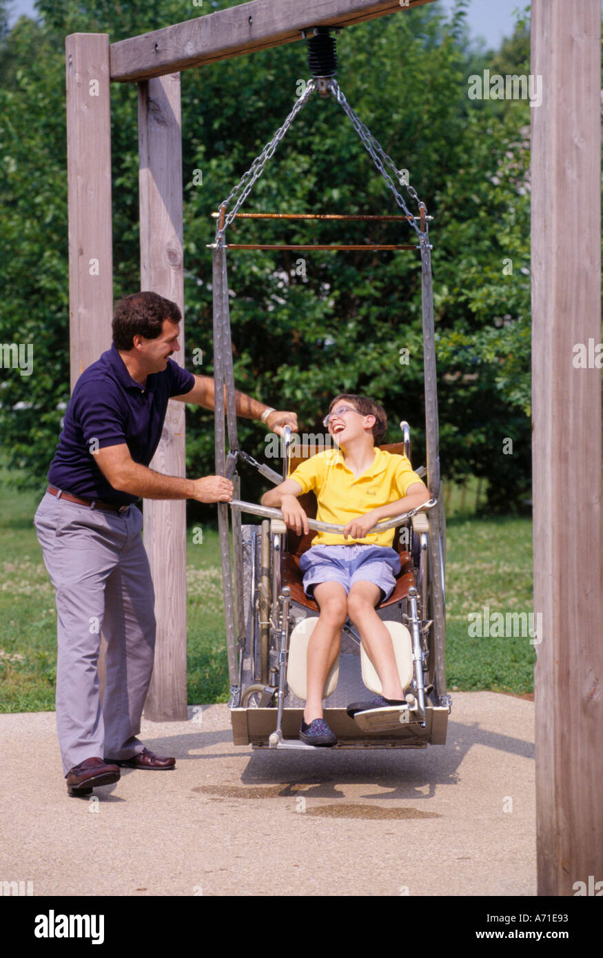 Man Helping A Handicapped Boy On A Wheelchair In A Handicapped
