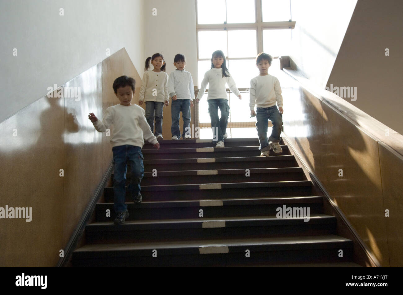 Children descending staircase Stock Photo