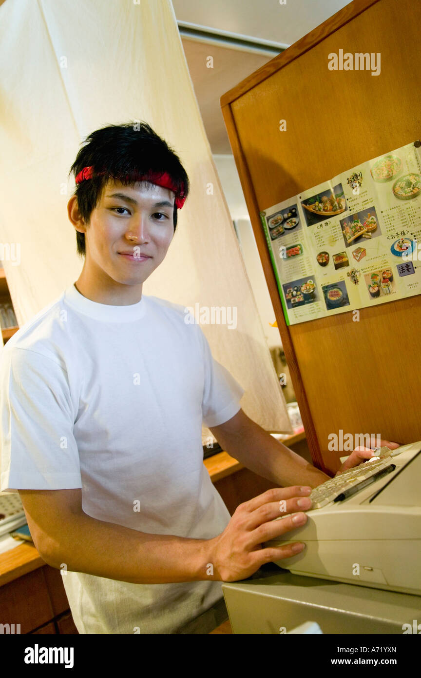 Young man working on cash register Stock Photo