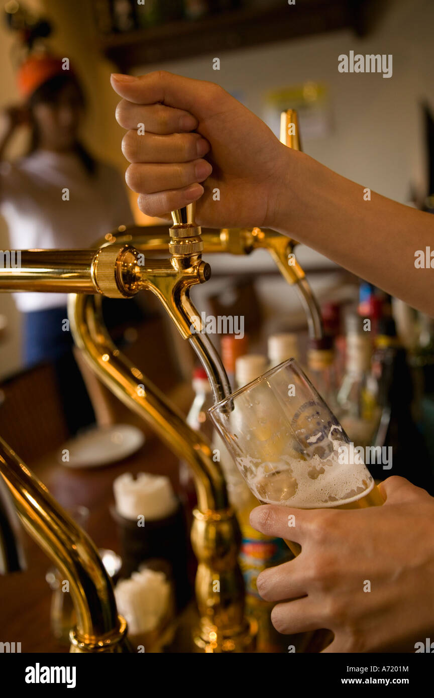 Bartender pouring beer to glass Stock Photo