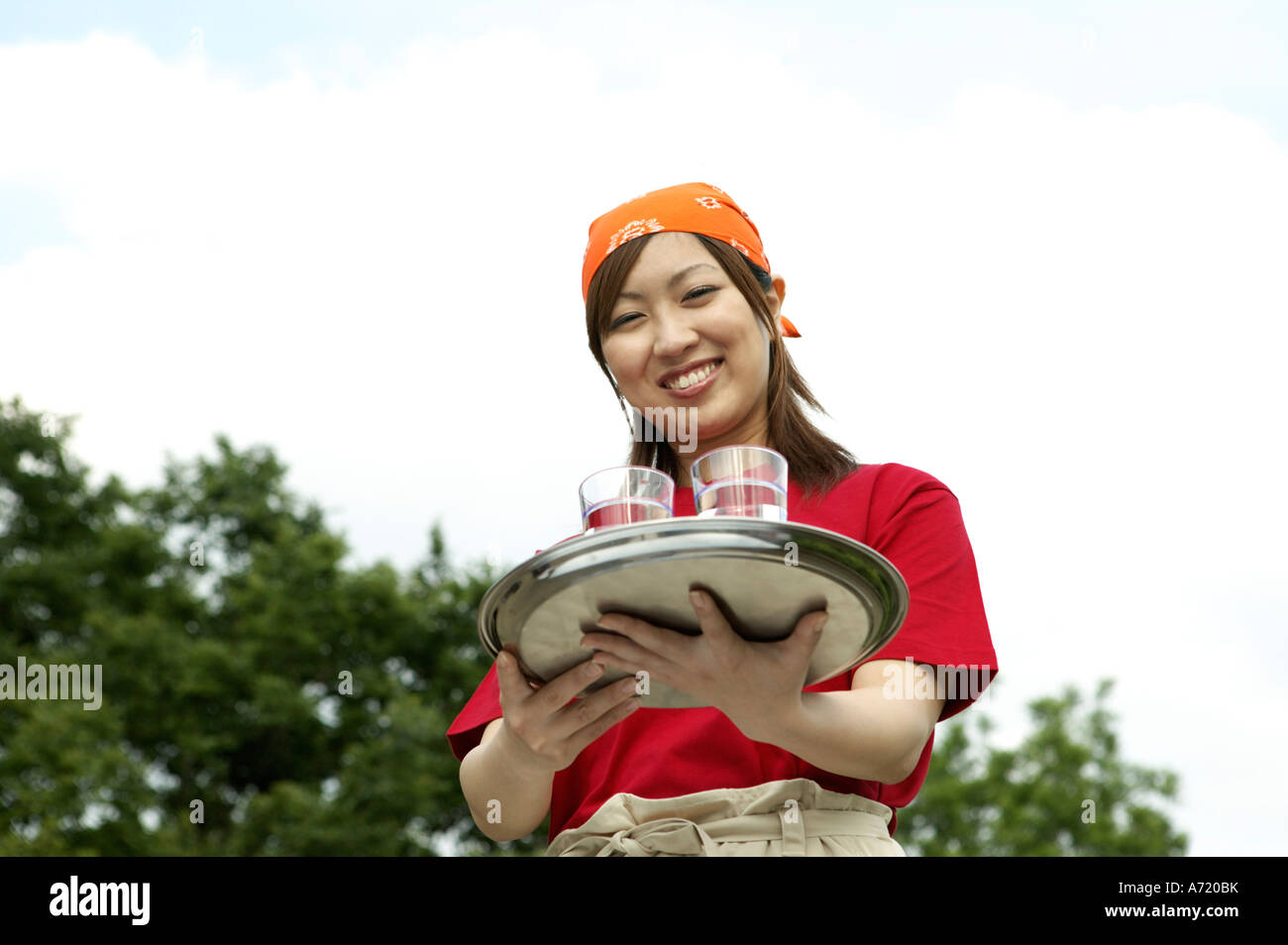 Waitress carrying drinks on tray Stock Photo Alamy