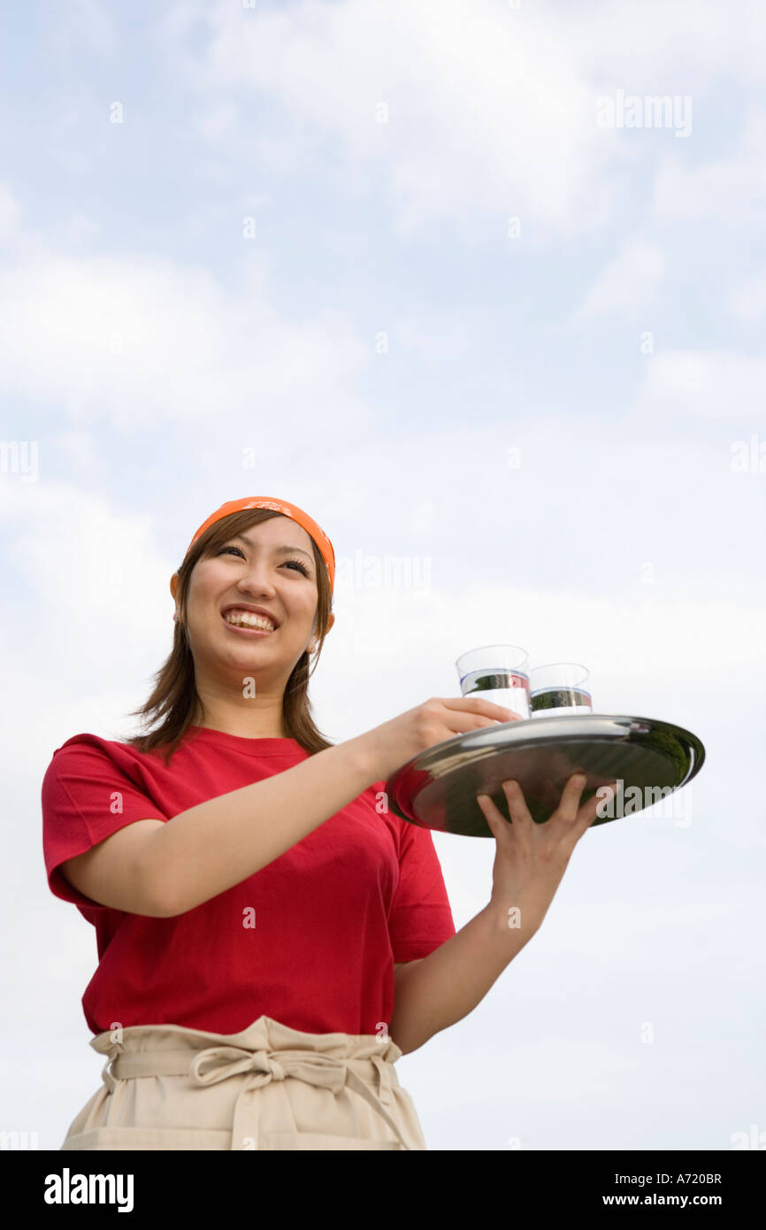 Waitress carrying drinks on tray Stock Photo Alamy