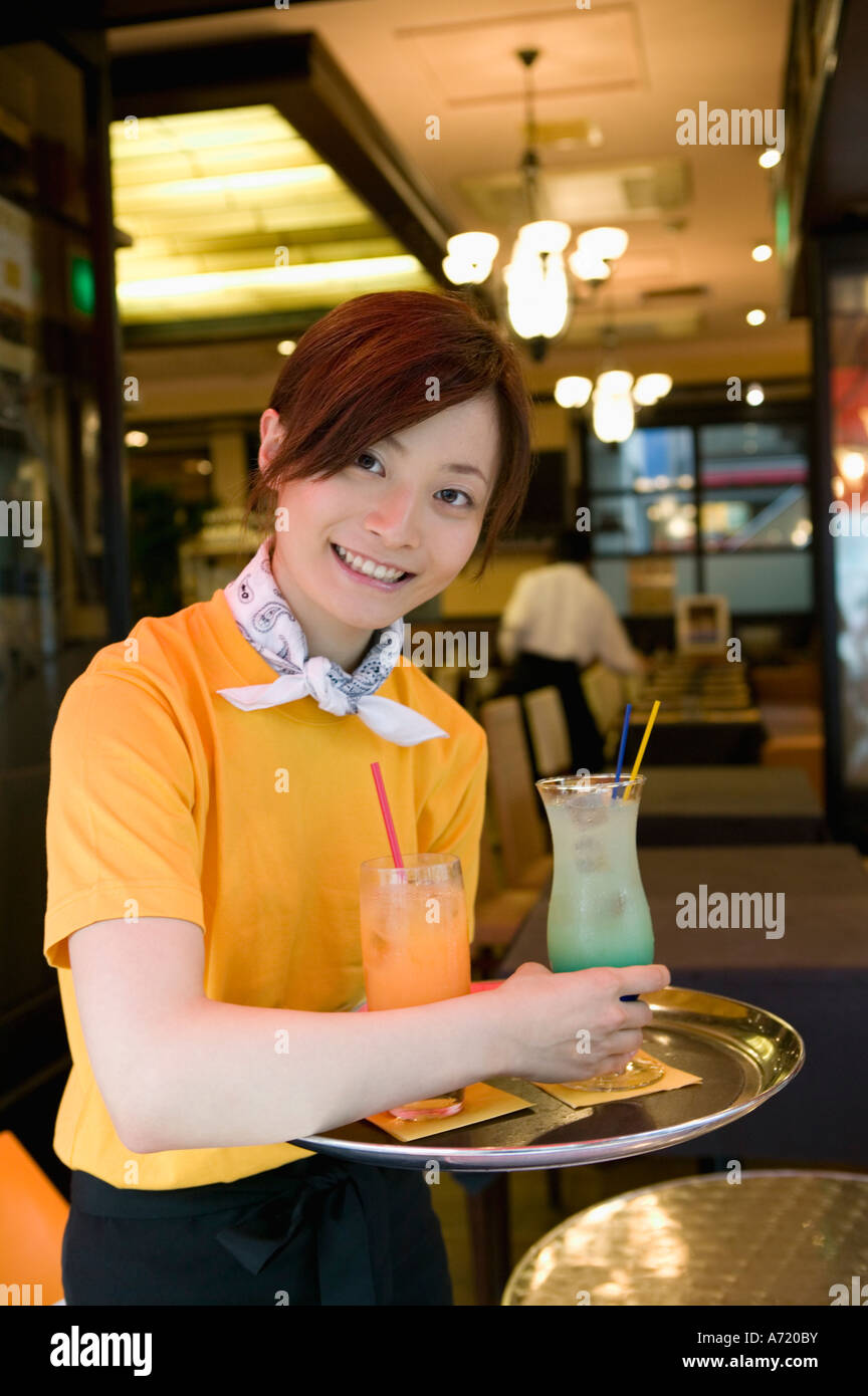 Waitress carrying drinks on tray Stock Photo Alamy