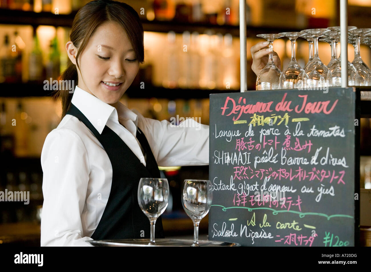 Waitress putting glasses on tray Stock Photo Alamy